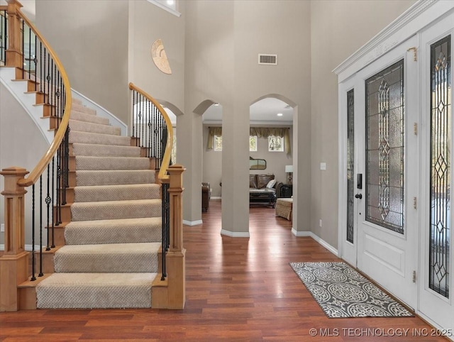 entryway featuring dark hardwood / wood-style flooring and a towering ceiling