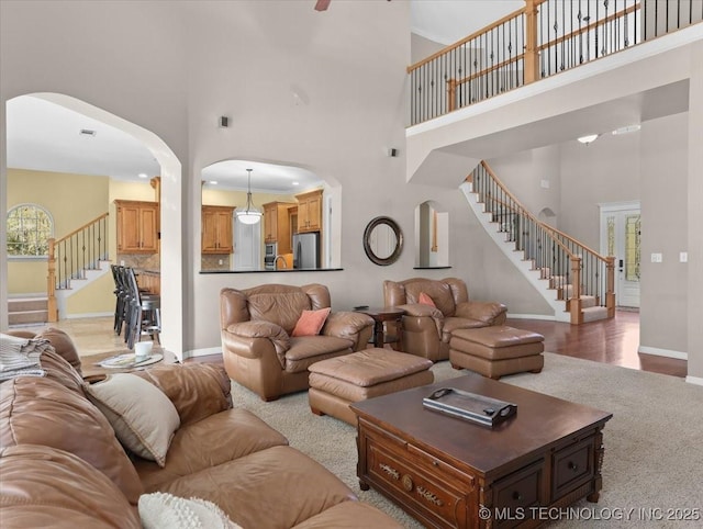 living room featuring a towering ceiling and wood-type flooring