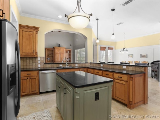 kitchen with pendant lighting, sink, stainless steel appliances, a kitchen island, and kitchen peninsula