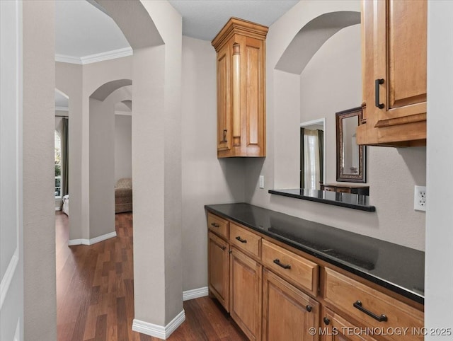 kitchen with dark wood-type flooring and ornamental molding