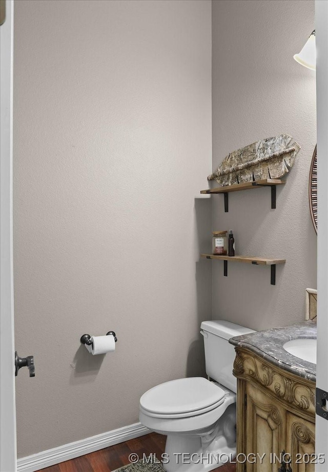 bathroom featuring vanity, hardwood / wood-style flooring, and toilet