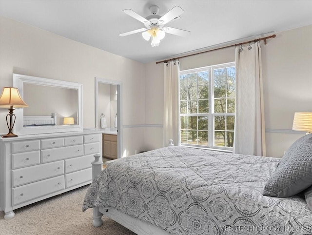 carpeted bedroom featuring ceiling fan and ensuite bath