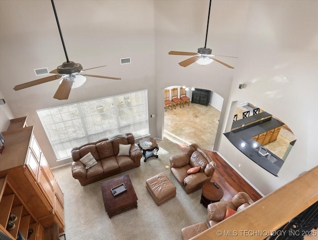 living room with a towering ceiling and ceiling fan