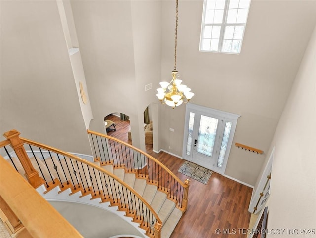 entryway featuring a high ceiling, an inviting chandelier, and dark hardwood / wood-style flooring