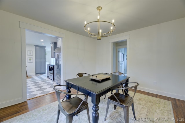 dining room with light wood-type flooring and an inviting chandelier