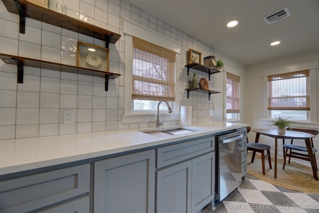 kitchen with gray cabinets, dishwasher, sink, and backsplash