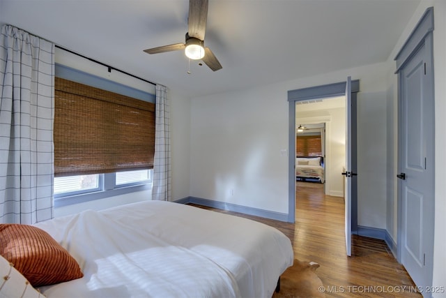 bedroom featuring hardwood / wood-style flooring, ceiling fan, and a closet