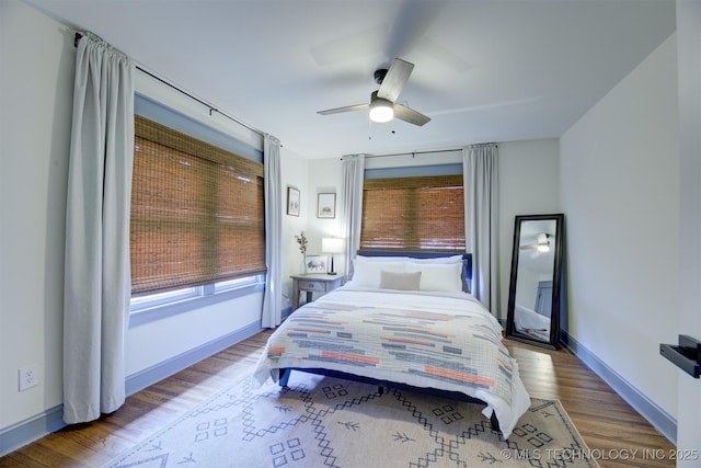 bedroom featuring multiple windows, wood-type flooring, and ceiling fan