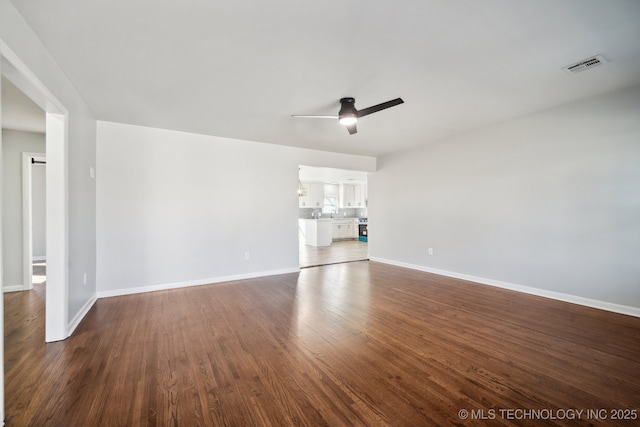 unfurnished living room with dark hardwood / wood-style floors and ceiling fan