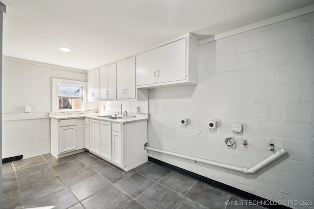 clothes washing area with gas dryer hookup, dark tile patterned floors, sink, and electric dryer hookup