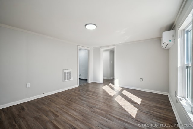 empty room featuring ornamental molding, dark hardwood / wood-style floors, and a wall unit AC