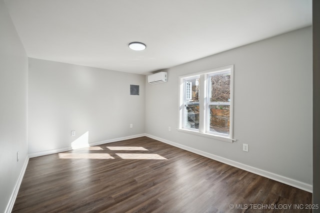 unfurnished room featuring dark wood-type flooring and a wall mounted AC