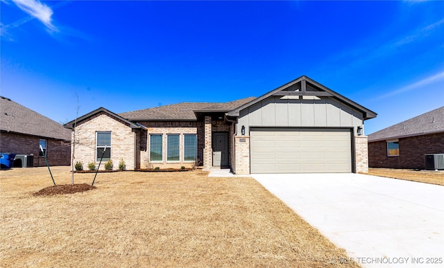 view of front facade featuring concrete driveway, brick siding, central AC, and an attached garage