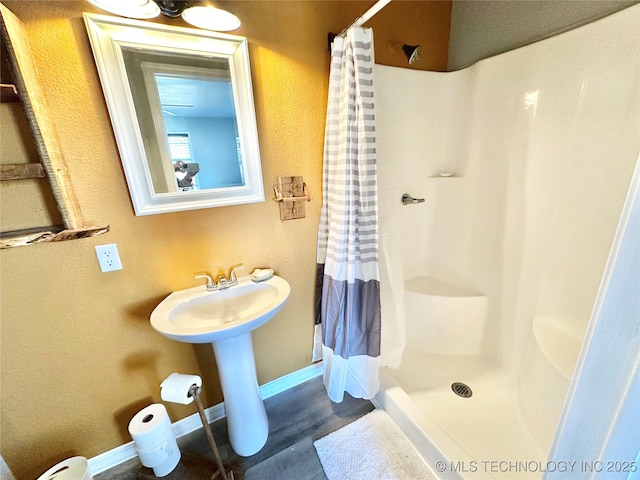 610 SW 7th Rd, Stigler, OK 74462 - full bath with a sink, baseboards, a stall shower, and wood finished floors