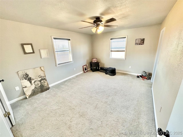 610 SW 7th Rd, Stigler, OK 74462 - interior space featuring carpet, a textured ceiling, baseboards, and ceiling fan
