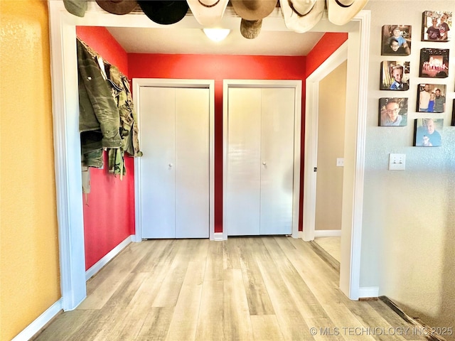 610 SW 7th Rd, Stigler, OK 74462 - unfurnished bedroom with multiple closets, wood finished floors, and baseboards