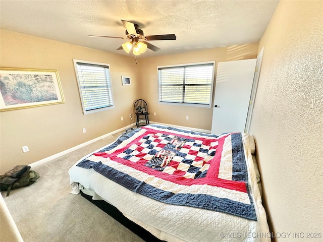 carpeted bedroom with ceiling fan and a textured ceiling