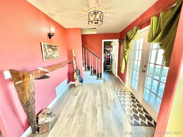 610 SW 7th Rd, Stigler, OK 74462 - foyer entrance featuring visible vents, stairway, a chandelier, wood finished floors, and baseboards