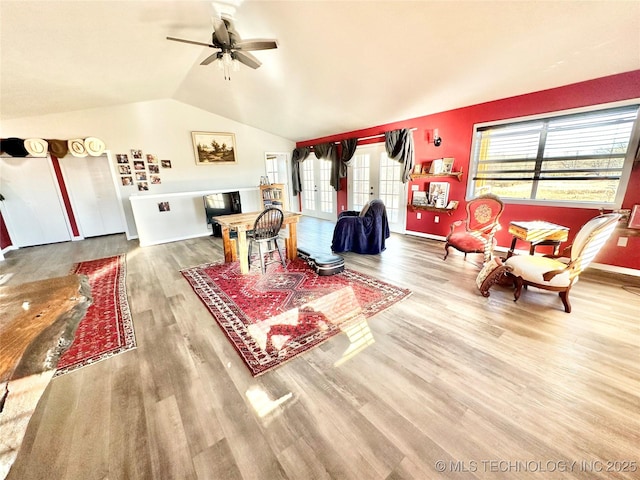 living room with lofted ceiling, hardwood / wood-style flooring, french doors, and ceiling fan