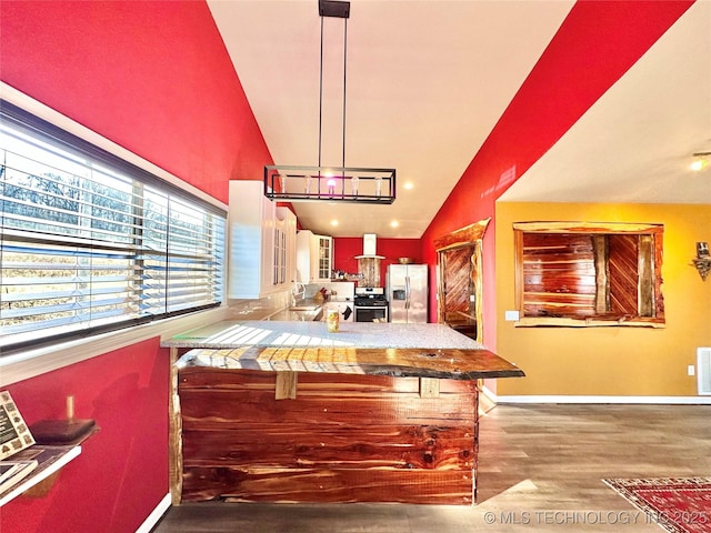 kitchen with appliances with stainless steel finishes, hanging light fixtures, a kitchen breakfast bar, vaulted ceiling, and kitchen peninsula