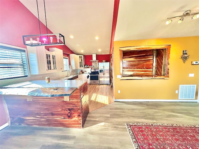 kitchen with sink, white cabinetry, decorative light fixtures, light hardwood / wood-style flooring, and appliances with stainless steel finishes