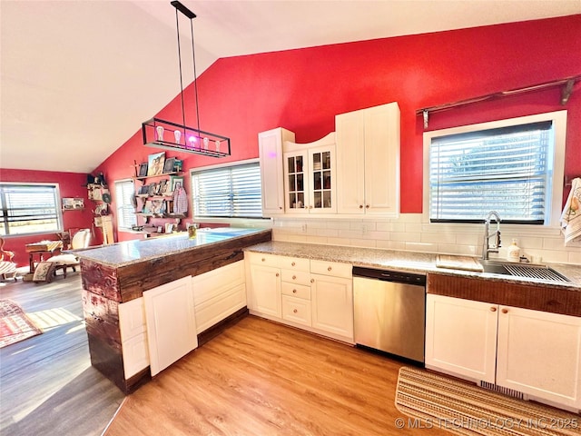 kitchen featuring pendant lighting, lofted ceiling, sink, white cabinets, and stainless steel dishwasher