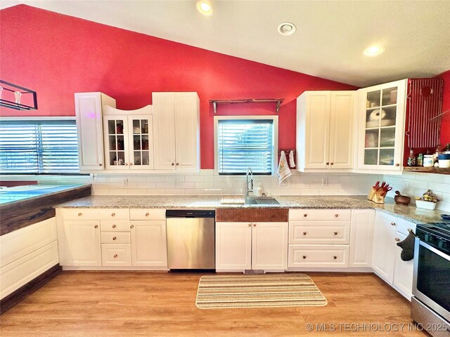 610 SW 7th Rd, Stigler, OK 74462 - kitchen featuring a sink, white cabinets, vaulted ceiling, and stainless steel appliances