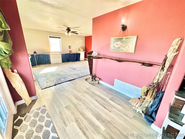 interior space with wood-type flooring and ceiling fan