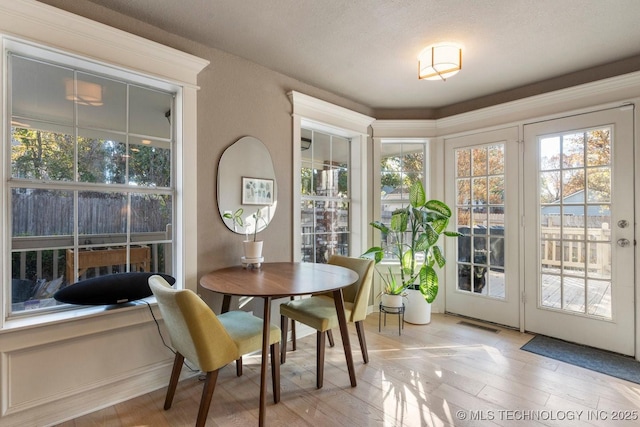 dining space with light hardwood / wood-style floors and a healthy amount of sunlight