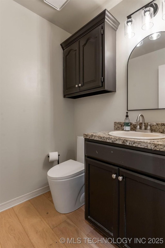 bathroom featuring vanity, hardwood / wood-style floors, and toilet