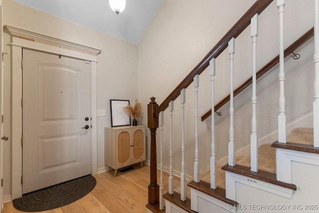 foyer with vaulted ceiling and light wood-type flooring