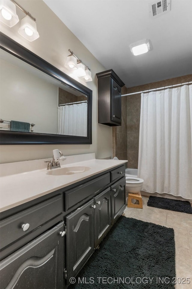 bathroom featuring vanity, toilet, and tile patterned flooring