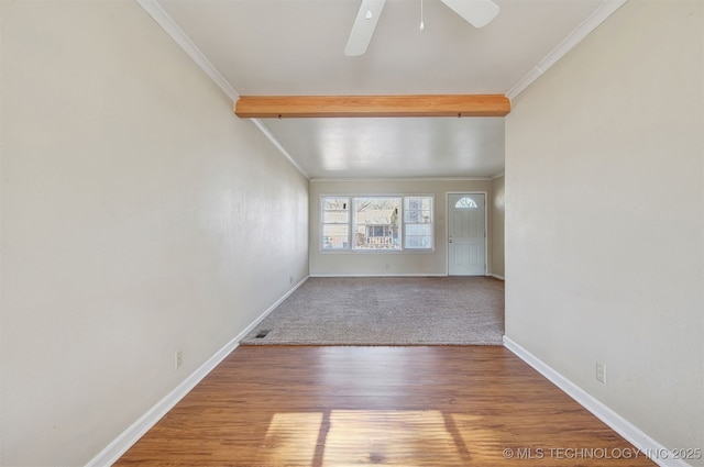 empty room featuring crown molding, ceiling fan, wood-type flooring, and beamed ceiling