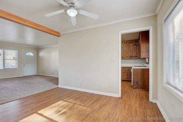 unfurnished living room featuring crown molding, ceiling fan, and light hardwood / wood-style floors