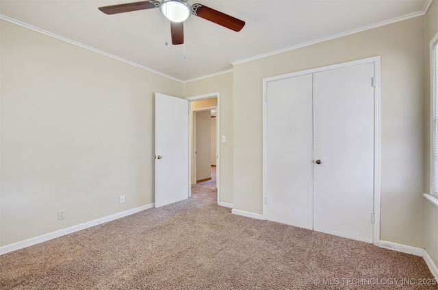 unfurnished bedroom featuring ornamental molding, a closet, ceiling fan, and carpet