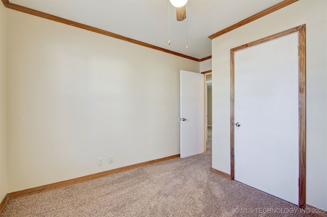 unfurnished bedroom featuring ceiling fan, ornamental molding, and carpet floors