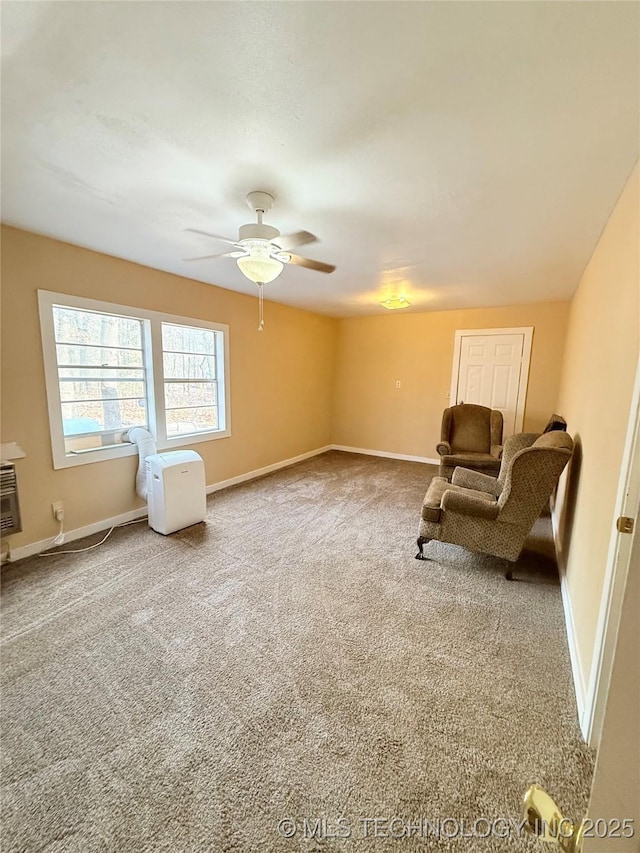 sitting room with ceiling fan and carpet