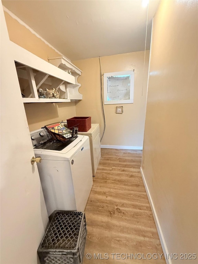 clothes washing area with washer and dryer and light hardwood / wood-style floors