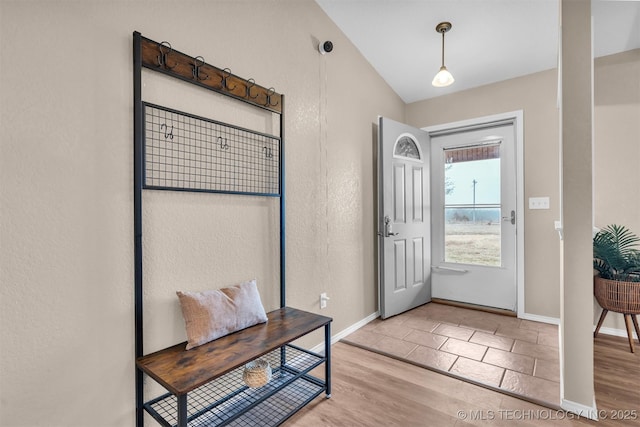 entrance foyer with vaulted ceiling and light hardwood / wood-style floors