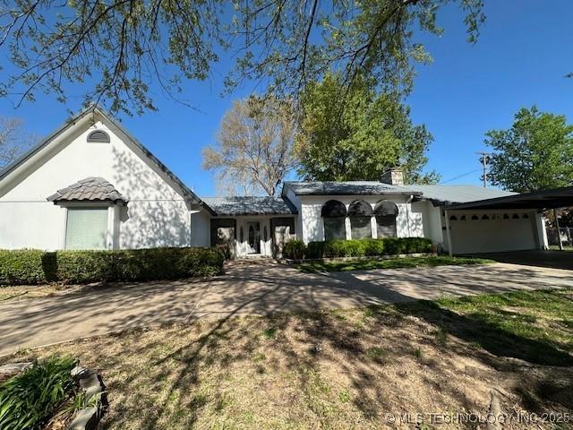 ranch-style house featuring a garage and a carport