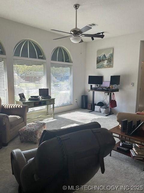 living room with ceiling fan and carpet