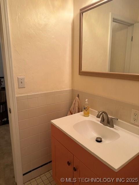 bathroom with vanity, tile patterned flooring, and tile walls