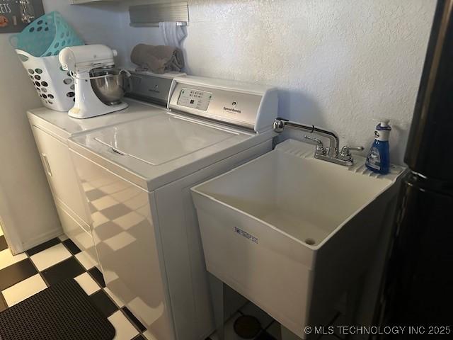 washroom with separate washer and dryer and sink