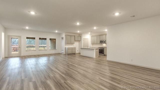 unfurnished living room featuring sink and light wood-type flooring