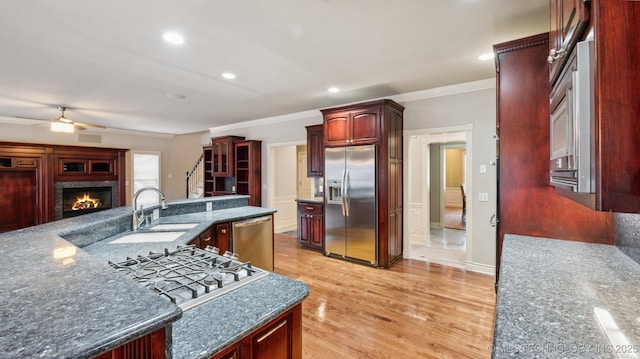 kitchen with sink, ornamental molding, appliances with stainless steel finishes, ceiling fan, and light hardwood / wood-style floors