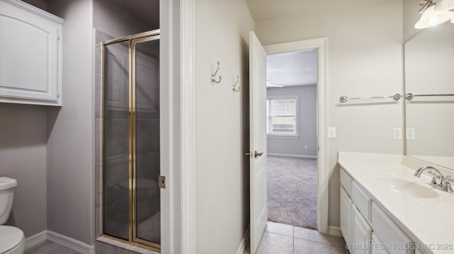 bathroom featuring vanity, tile patterned flooring, toilet, and walk in shower