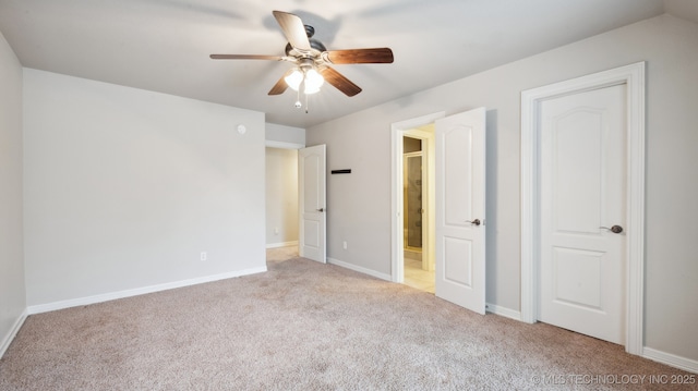 unfurnished bedroom featuring ceiling fan, light colored carpet, and ensuite bath