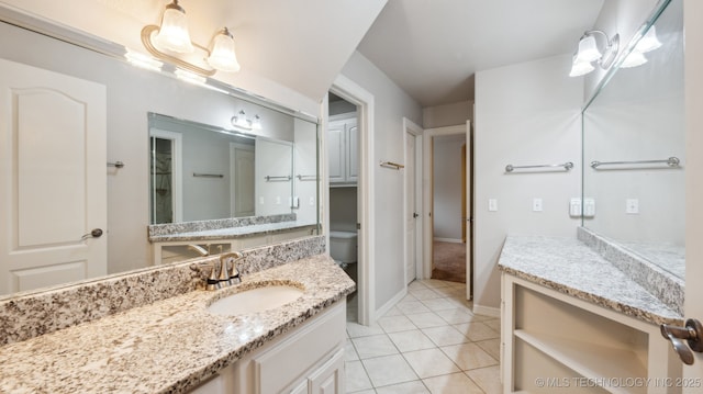 bathroom with tile patterned flooring, vanity, toilet, and an inviting chandelier