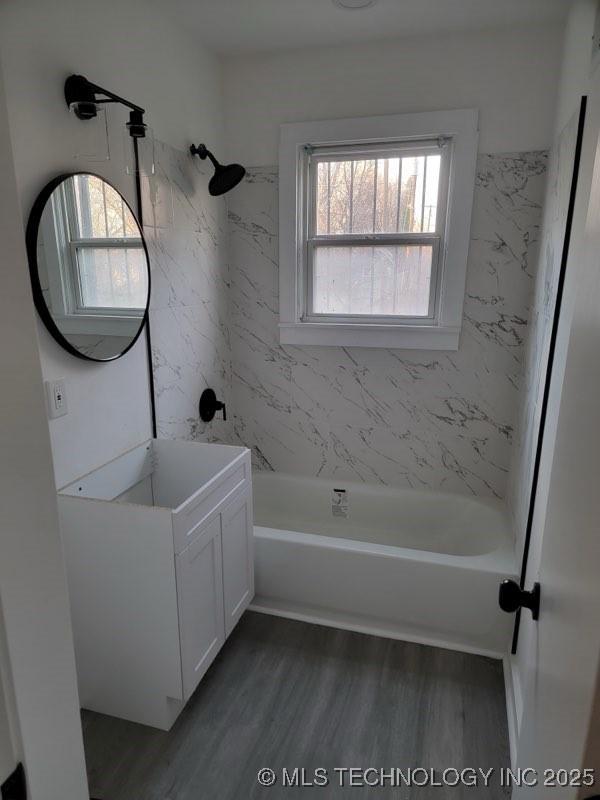 bathroom featuring vanity, hardwood / wood-style floors, and tiled shower / bath