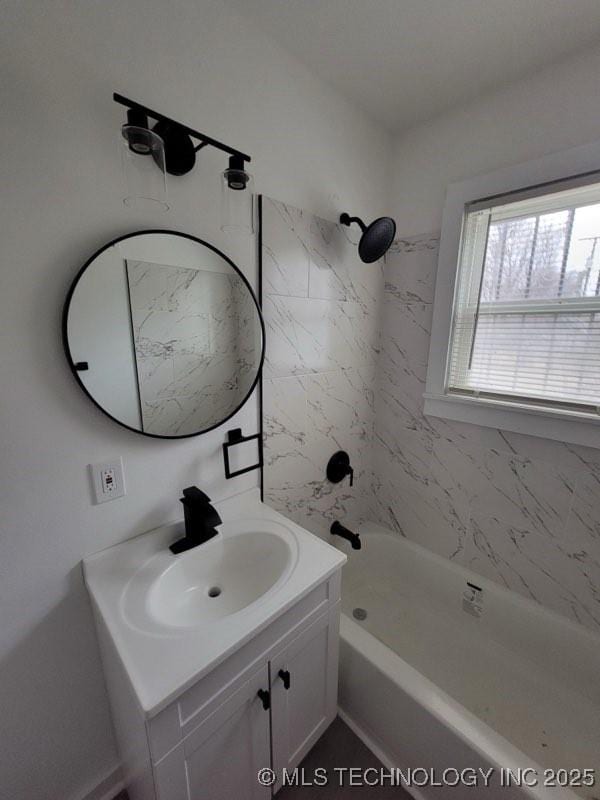 bathroom with tiled shower / bath combo and vanity